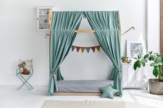 a bedroom with a canopy bed and green drapes on the windowsill, potted plants