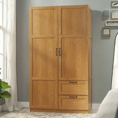 a wooden armoire in a bedroom next to a window