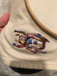 someone is stitching on the back of a hat