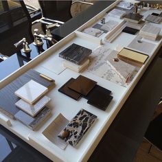 a table topped with lots of books on top of a white counter next to a black chair