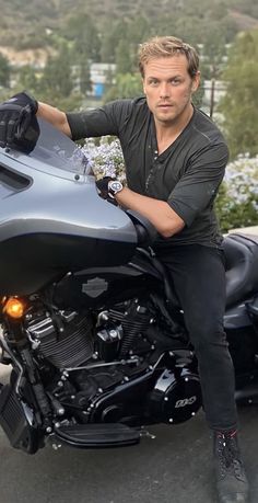 a man sitting on top of a black motorcycle