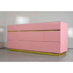 a pink and gold dresser sitting in a room