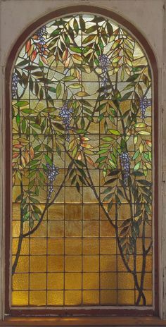 a stained glass window with blue berries and leaves on it's side, in an old building