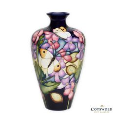 a vase with flowers and butterflies painted on the front, sitting against a white background