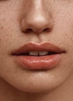 a woman's face with freckles on her cheeks and nose, close up