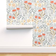 the wall paper has an orange flower pattern on it and is next to a white door