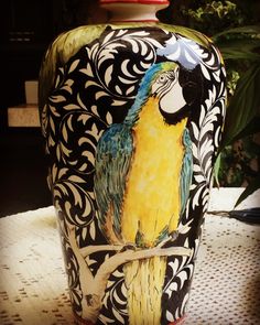 a decorative vase with a parrot painted on it