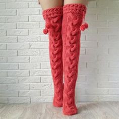 woman's legs in red knitted boots with pom - poms on them