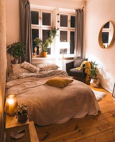 a bed room with a neatly made bed next to a window and a mirror on the wall