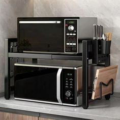 a microwave oven sitting on top of a counter next to a cutting board and utensils