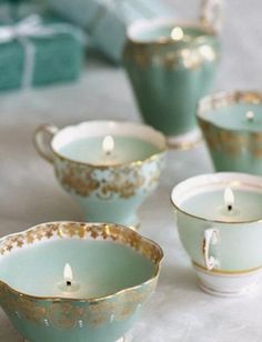 tea cups with candles in them sitting on a table