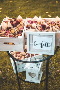 two wooden boxes filled with flowers sitting on top of a metal stand in the grass