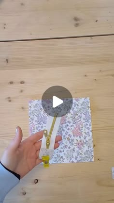 a person is cutting paper with scissors on a wooden table