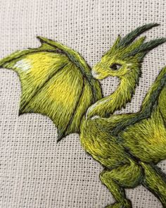 a green dragon embroidered onto a white cloth