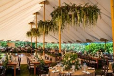 the inside of a large tent with tables and chairs set up for an outdoor function