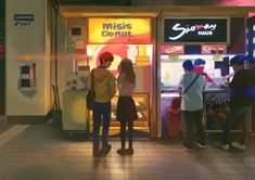 three people standing in front of a donut shop looking into the window at customers