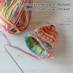 two balls of yarn and a ball of knitting needles