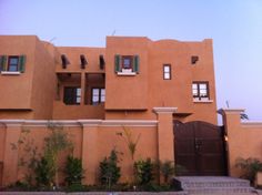 a large brown building with green shutters and windows