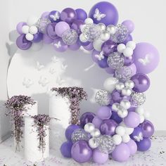 purple and white balloons are arranged in the shape of a wreath