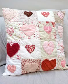 a pillow with hearts on it sitting on a couch