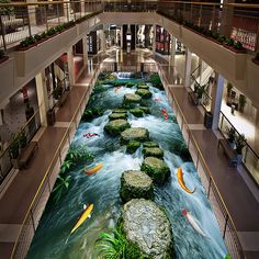 an indoor shopping mall with fish swimming in the water and plants growing on the floor