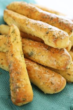 some very tasty looking bread sticks on a blue cloth with seasoning sprinkles