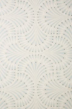 a blue and white wallpaper with small dots on the top, in an ornate pattern