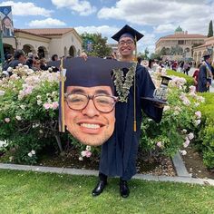 a man wearing glasses and a graduation cap poses for a photo with a fake graduate's head