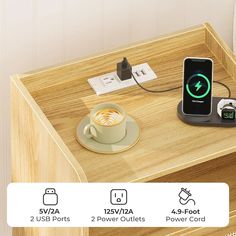 an iphone charging on top of a wooden table next to a cup and saucer