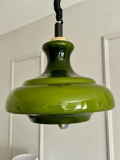 a green light hanging from a ceiling in a room