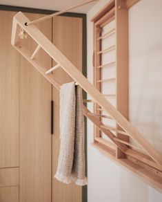 a towel hanging from a clothes rack in a room with wooden closets and cabinets