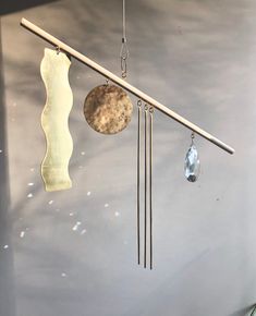 a wind chime hanging from the side of a wall with two pendulums attached to it