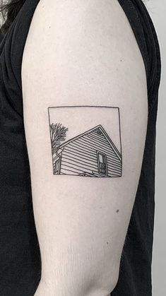 a black and white photo of a house on the back of a woman's arm