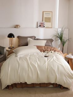 a bed with white sheets and pillows in a room