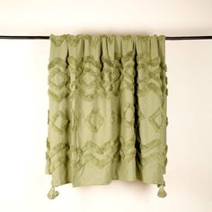 a green curtain hanging on a clothes line