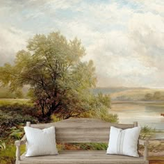 a wooden bench sitting in front of a painting on the side of a wall next to a body of water