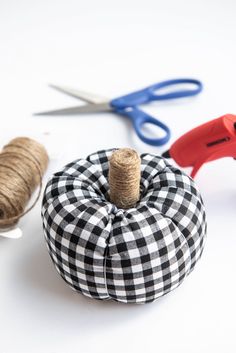 some twine spools sitting on top of a black and white checkered pumpkin