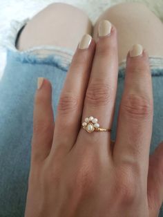 This dainty little pearl cluster ring is a nod to a bohemian vintage style. I've hand hammered the band for strength, texture and shine, then wrapped sweet freshwater pearls in a half halo/flower style. Delicate but strong, this ring is very lightweight and comfortable! ~Choose from~ 14k gold fill 14k rose gold fill Sterling silver What is 14k Gold-fill? Gold fill does not tarnish or wear off and contains 100 times more gold than plated jewelry. It legally must contain at least 5% gold by weight Delicate Gold Ring With Pearl Charm, Delicate Pearl Charm Ring, Delicate Pearl Charm Ring Jewelry, Delicate Gold Rings With Pearl Charm, Handmade Dainty Pearl Open Ring, Dainty Handmade Pearl Open Ring, Delicate Open Pearl Ring With Pearl Drop, Delicate Open Pearl Ring With Drop Detail, Delicate Open Pearl Ring With Drop