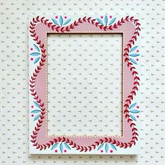 a pink and blue frame sitting on top of a white wall next to a polka dot background