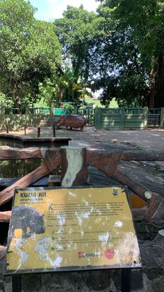 an animal exhibit in the middle of a park with animals on it's sides