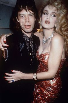 the man and woman are posing together for a photo in red sequins on their dresses