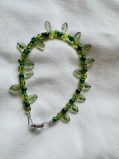 a green beaded bracelet with leaves on it