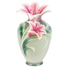 a white vase with pink flowers painted on the front and side, sitting against a white background