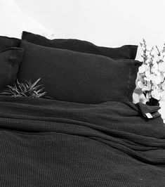 a black and white photo of a bed with flowers on it