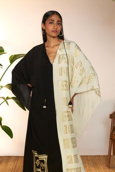 Introducing a chic mid-length kaftan, a perfect fusion of style and comfort. Crafted with a classic v-neckline and adorned with a contrasting border detail along the neckline and sleeve hem, this kaftan exudes understated elegance. The black contrast adds a sophisticated touch, while the mid-length design offers versatility for various occasions. Paired with a coordinating slip for added coverage and comfort, this kaftan is ideal for both casual outings and special events, ensuring you look effo Elegant V-neck Kurta For Festive Occasions, Elegant V-neck Kaftan For Festive Occasions, Festive Silk V-neck Dress, Elegant Silk Tunic For Eid, Elegant Festive V-neck Kurta, Elegant Silk Tunic For Festive Occasions, Elegant Festive Silk Tunic, Festive V-neck Kaftan, Elegant White V-neck Kaftan