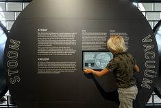 a young boy standing in front of a display