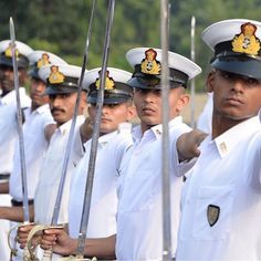 a group of men in uniform standing next to each other and pointing at something with one hand