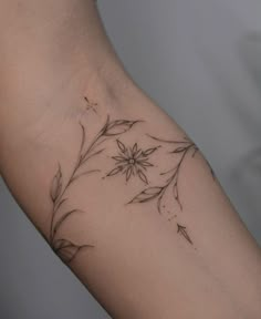 a woman's arm with a flower tattoo on it