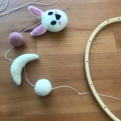 some toys are laying on the floor next to a string and yarn ball hoop with an animal head hanging from it's side