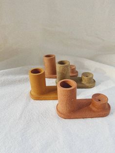 four small wooden objects sitting on top of a white sheet